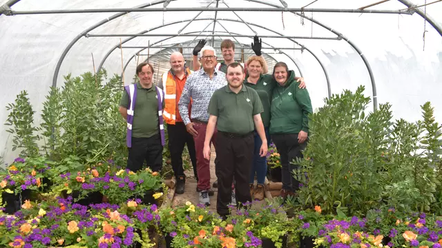 Cllr Hawkins and Representatives from Veolia and Newlands Bishop Farm stand amongst hanging baskets